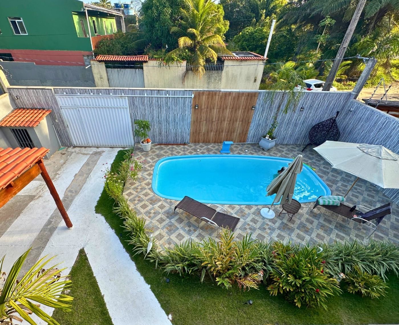 Área da piscina vista de cima, com gramado e espreguiçadeiras